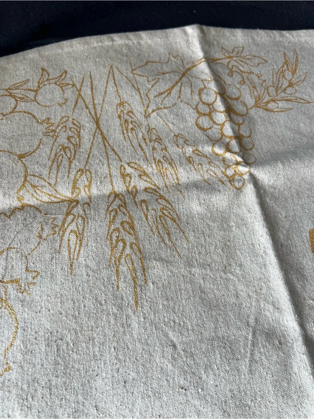 Gold and cream Shabbat tablecloth with gold Hebrew text and illustrations